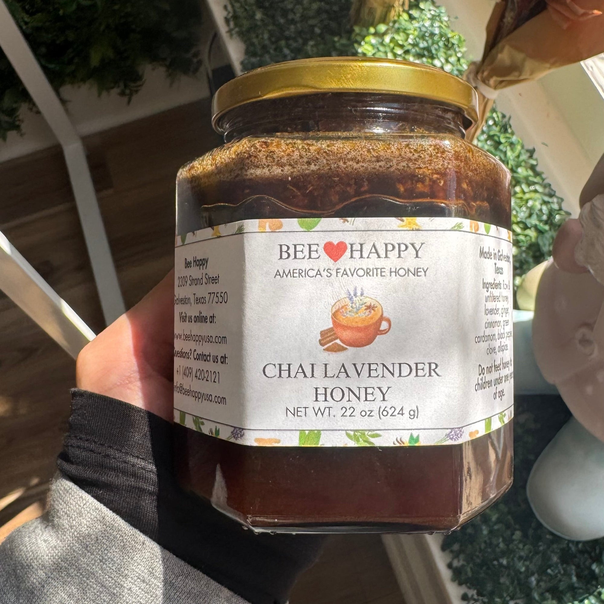 22 oz Jar of Chai Lavender Honey held by a person with a blurred background