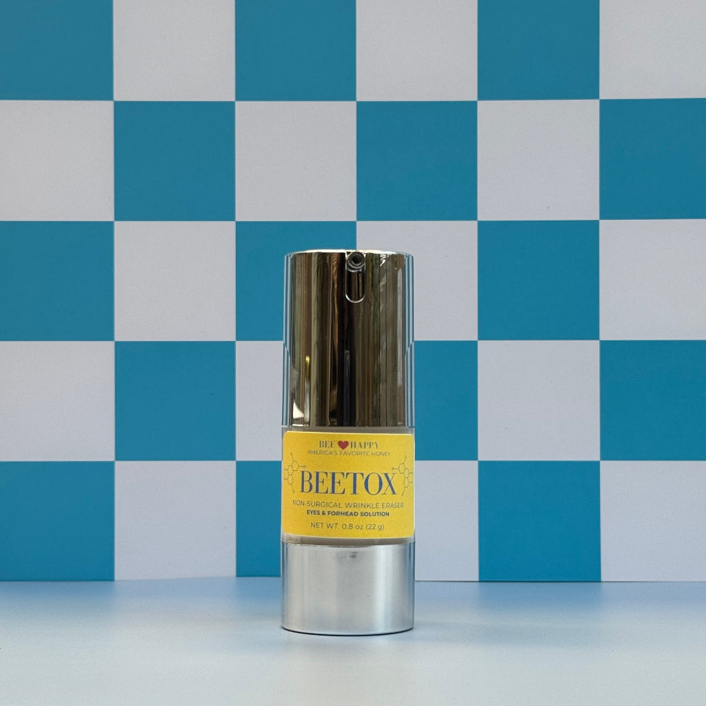 Bottle of 0.8 oz bottle of Bee Happy Beetox against a blue and white checkered background.
