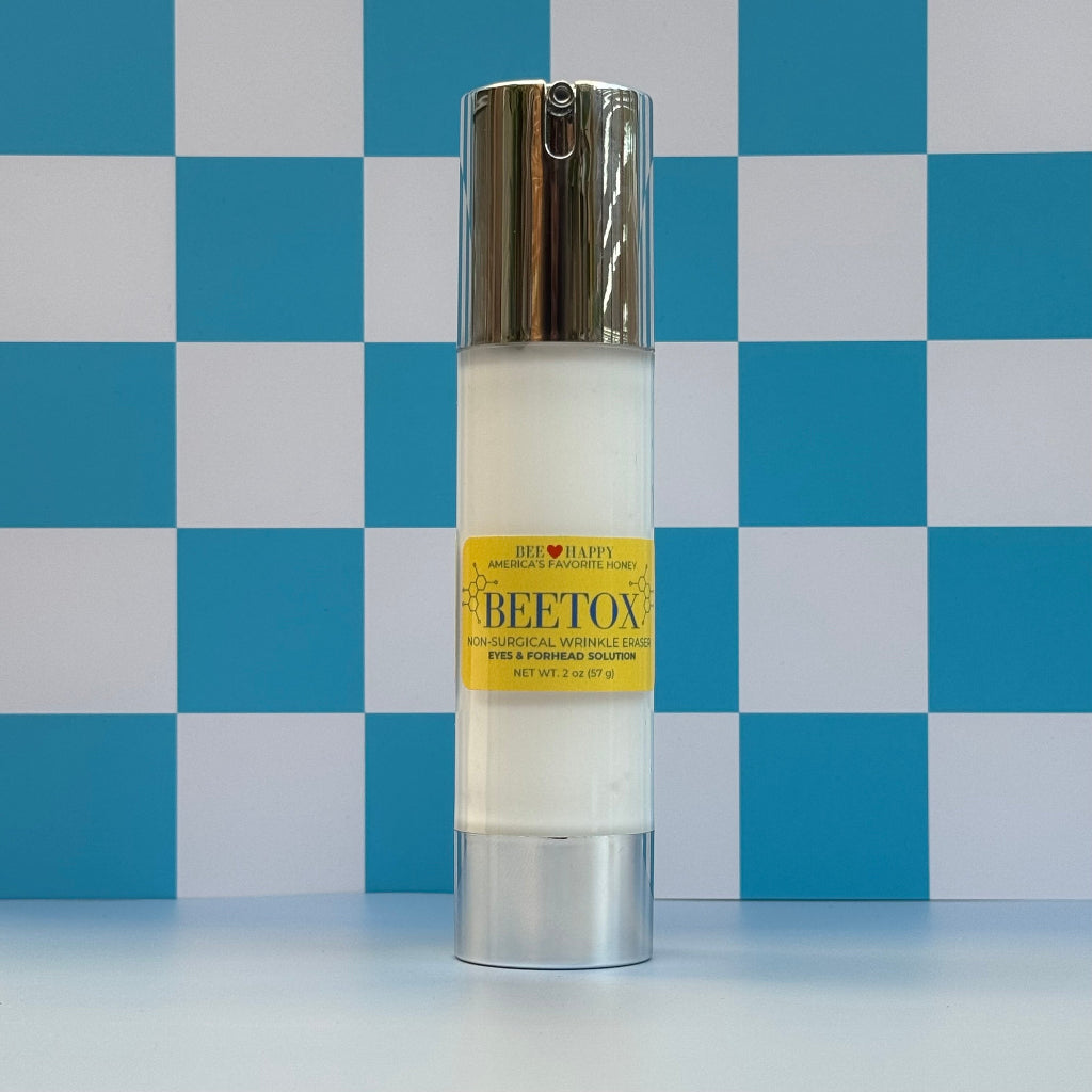 Bottle of 2 oz bottle of Bee Happy Beetox against a blue and white checkered background.