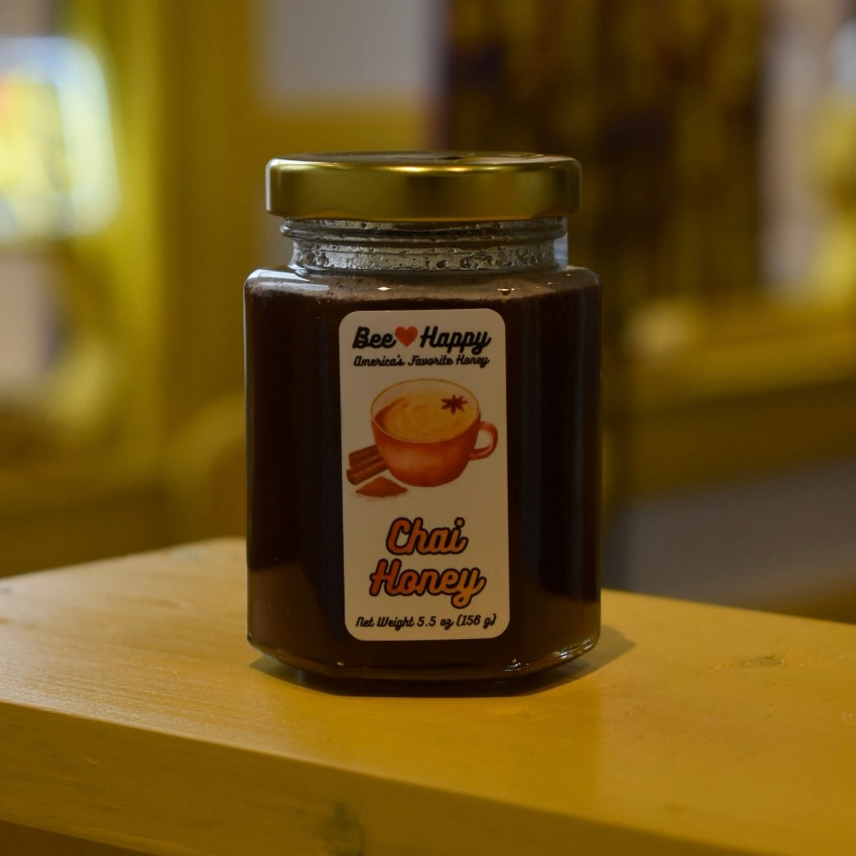 5.5 oz jar of Chai Honey on a wooden surface with a blurred background.