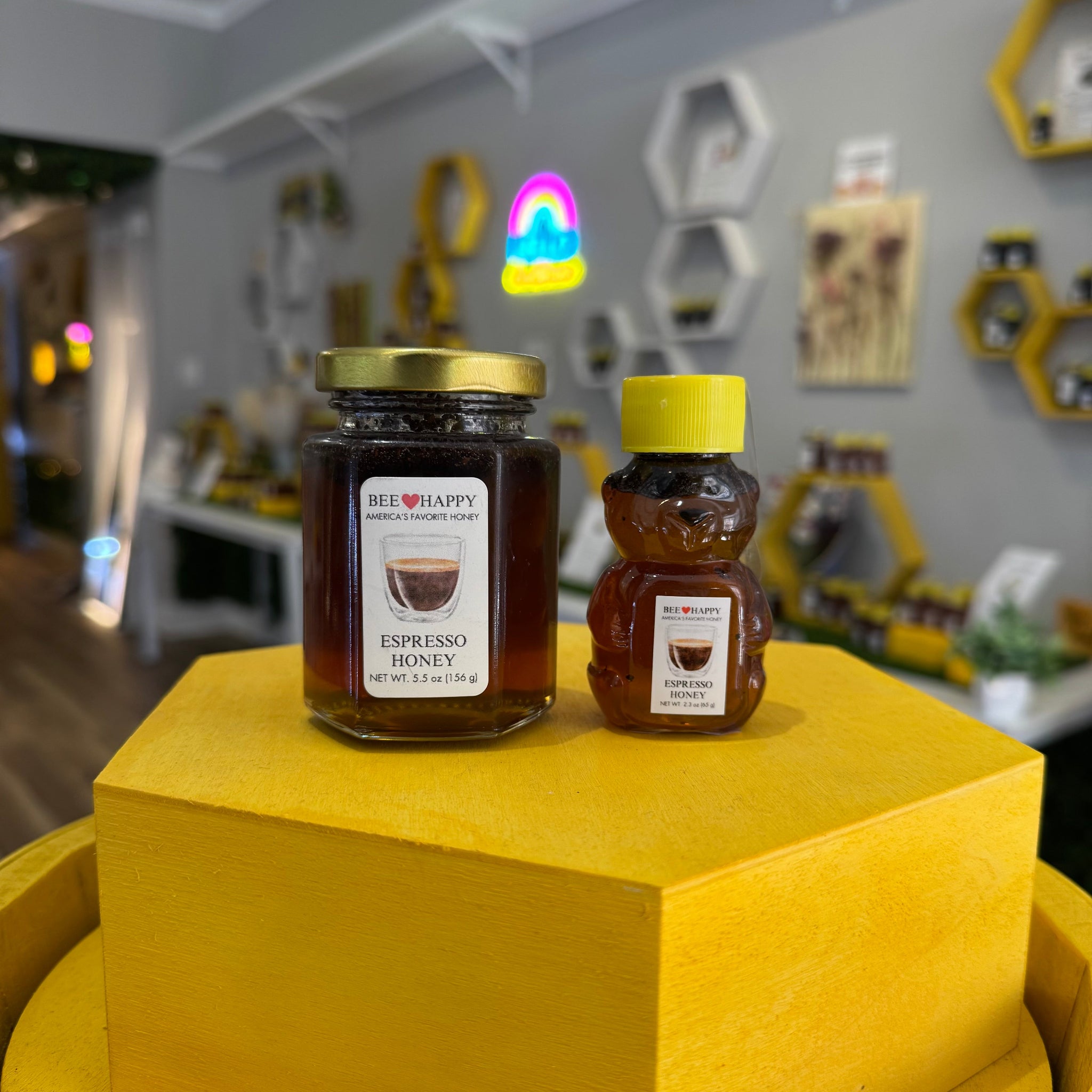 5.5 oz jar and 2.3 oz bear bottle of Espresso Honey on yellow wooden display