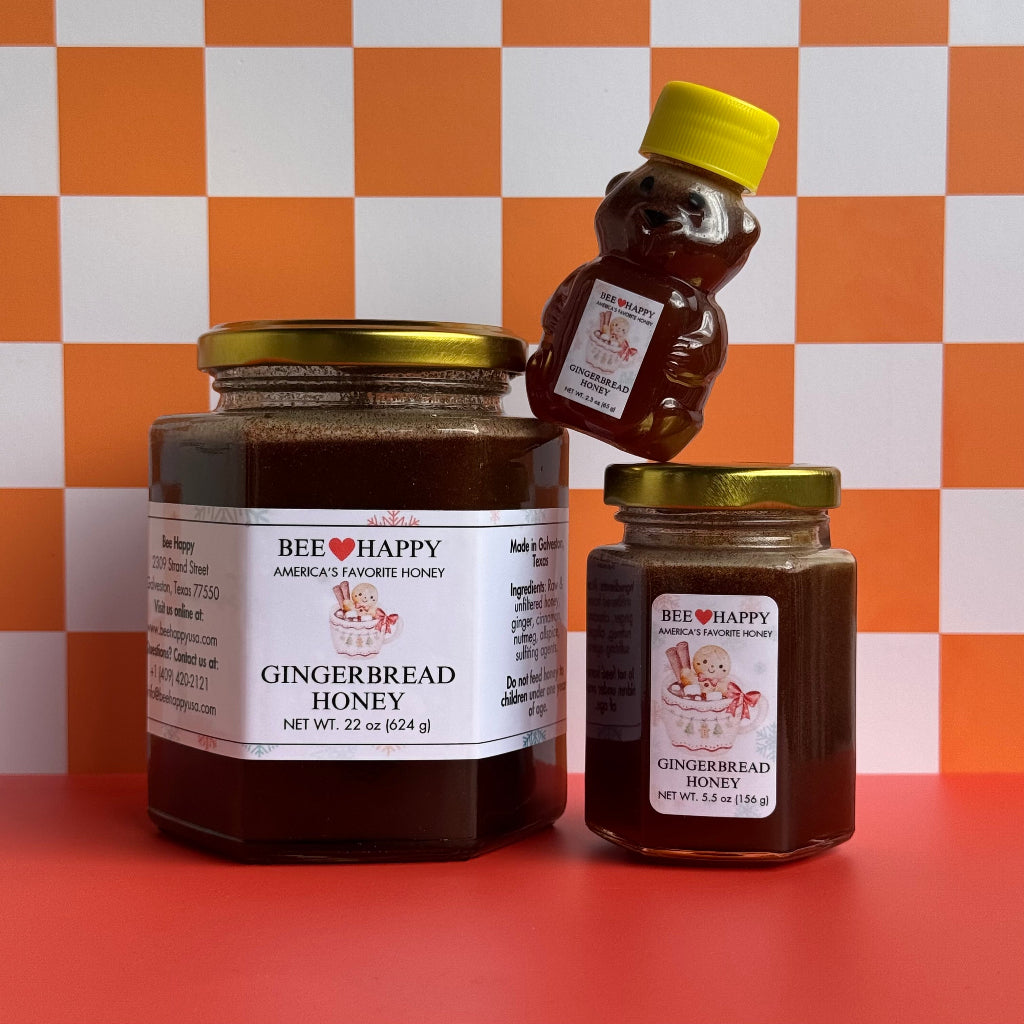 22 oz jar, 5.5 oz jar and 2.3 oz bear bottle of Bee Happy Gingerbread Honey against a checkered white and orange background.