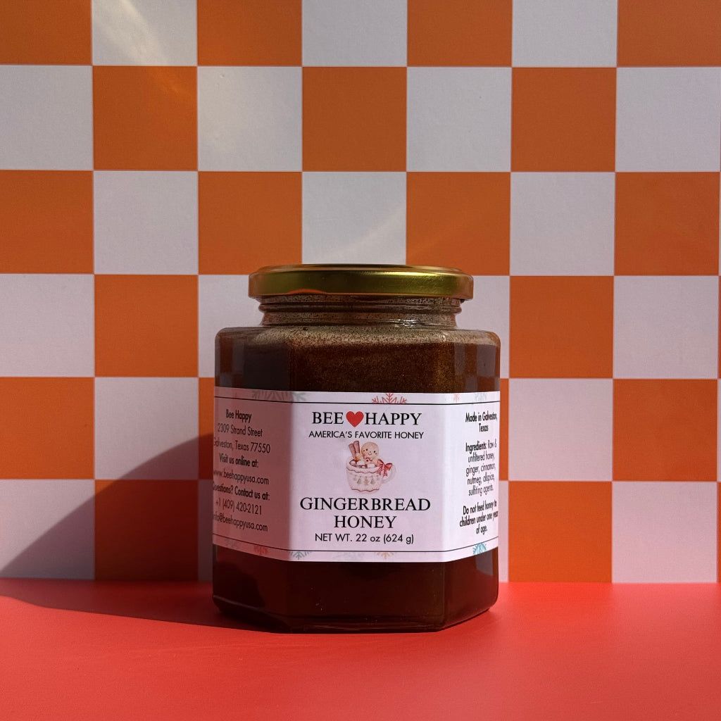 22 oz jar of Bee Happy Gingerbread Honey against a checkered white and orange background.