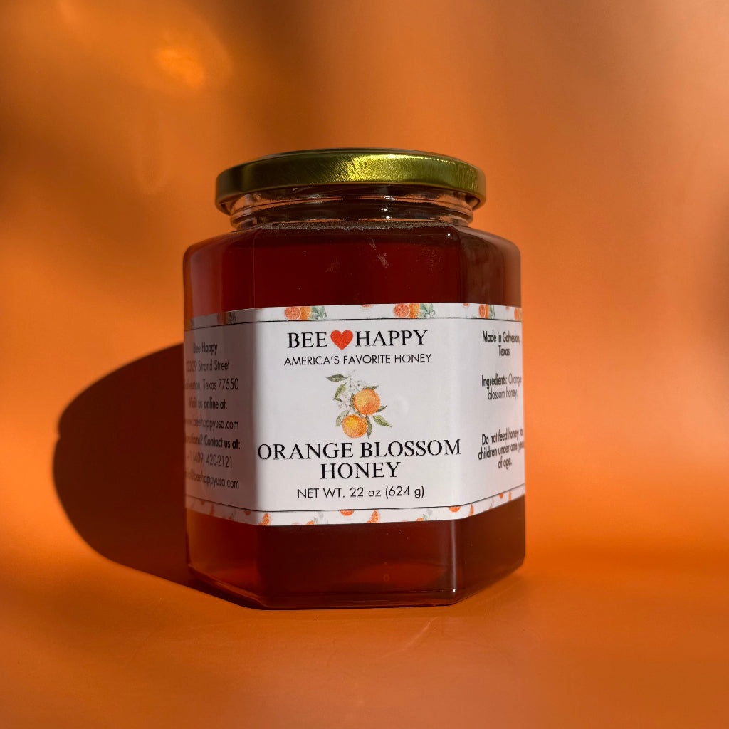 22 oz jar of Orange Blossom Honey against an orange background