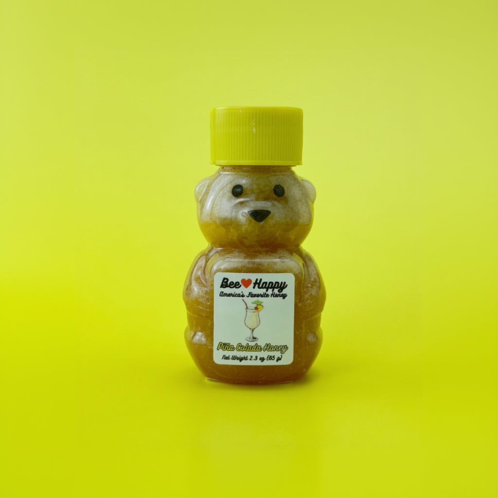 a 2.3 oz bear bottle of Pina Colada Honey against a yellow background