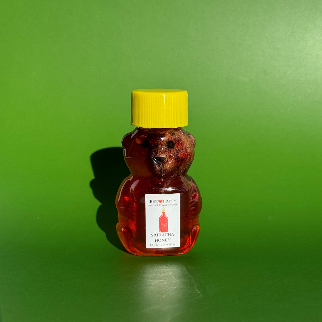 2.3 oz bear bottle of Sriracha Honey against a green background