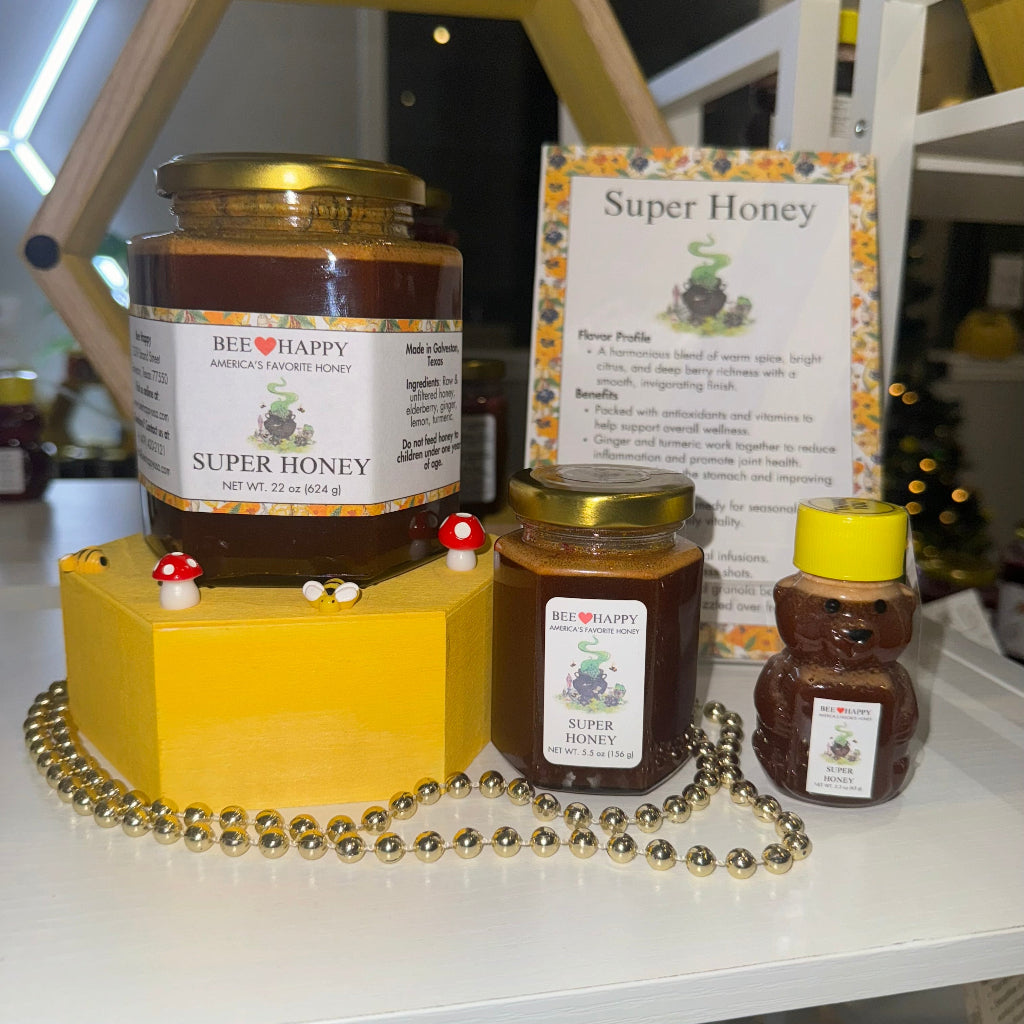 22 oz jar, 5.5 oz jar and 2.3 oz bear bottle of Super Honey with decorative elements on a table.