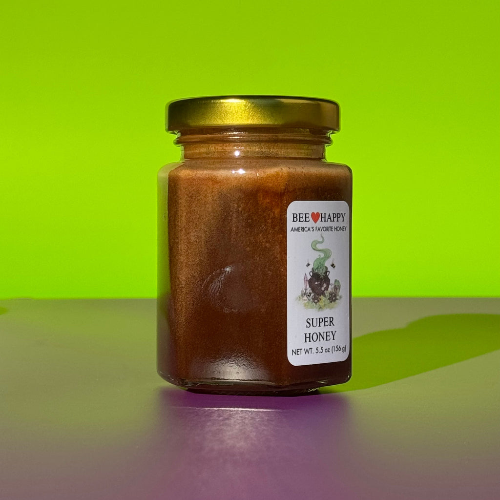5.5 oz jar of Bee Happy Super Honey on a green and purple background