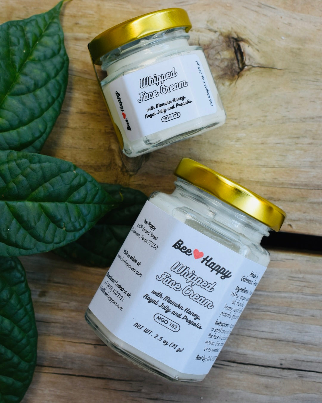 1 oz jar and 2.5 oz jar of Whipped Face Cream on a wooden background
