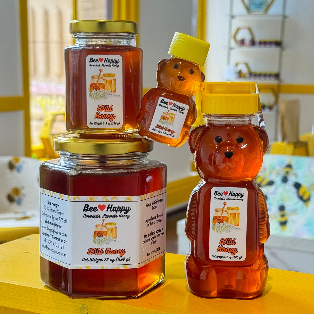 2.3 oz bear bottle, 5.5 oz jar, 12 oz bear bottle and 22 oz jar of Wild Honey, against a blurry background