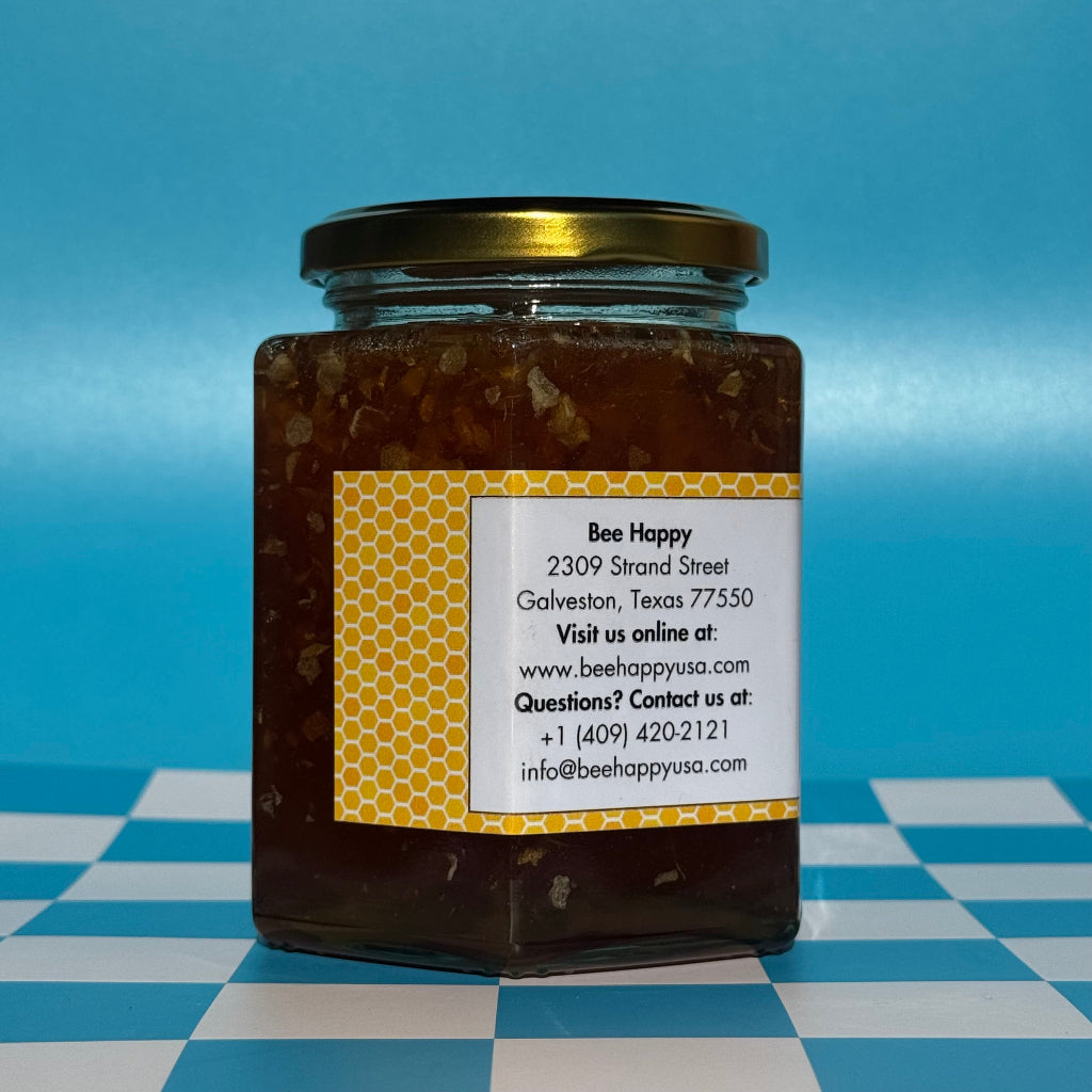22 oz jar of Bee Happy Wild Honey with Comb on a blue and white checkered background