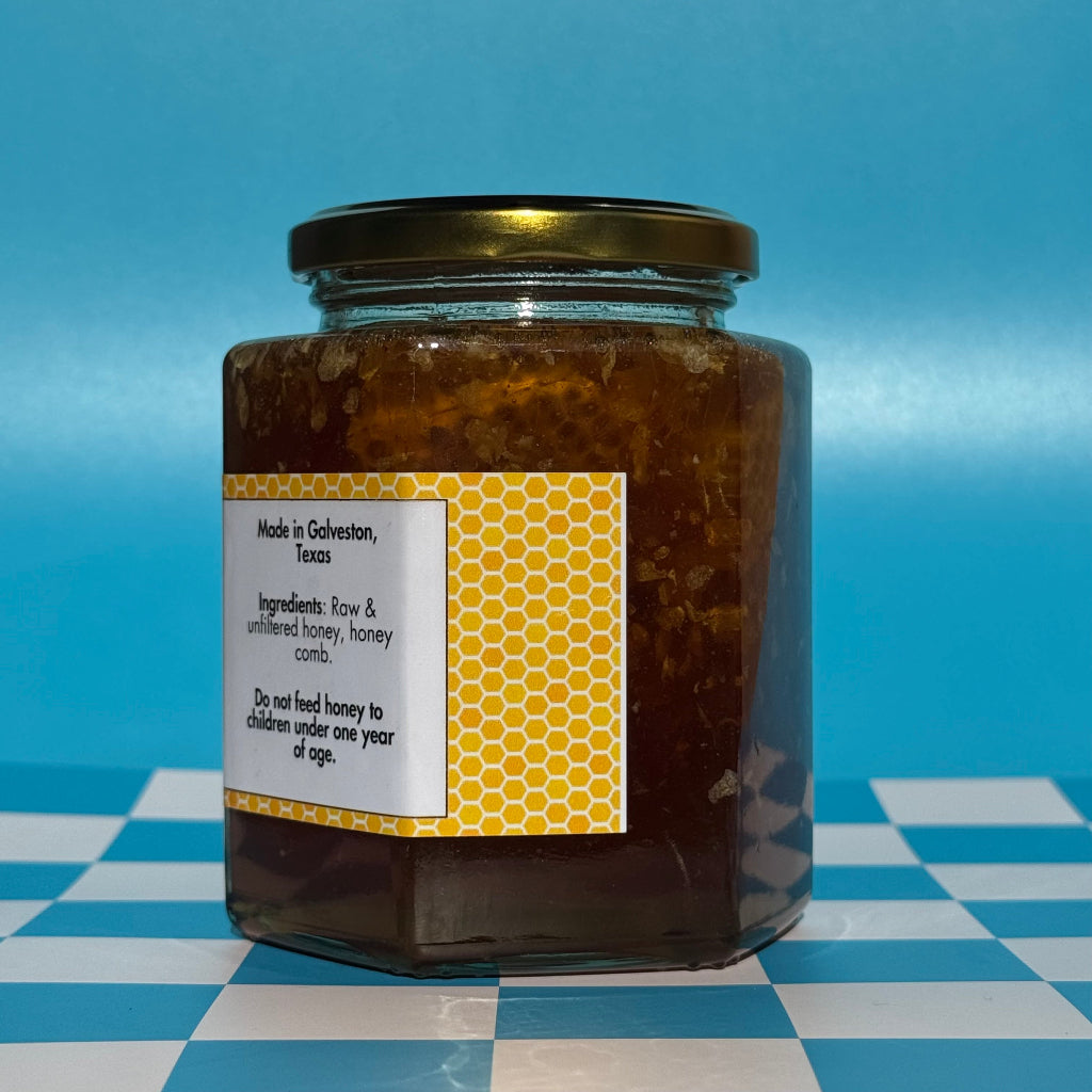 22 oz jar of Bee Happy Wild Honey with Comb on a blue and white checkered background